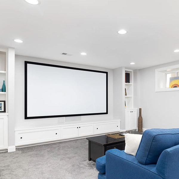 Basement home theater with large projector screen and blue seating.