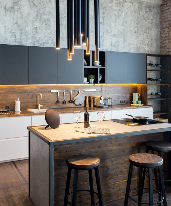 An industrial-style kitchen remodeling in Yorkville, IL with a dark wood island, tube pendant lighting, and sleek black cabinetry against a concrete wall.