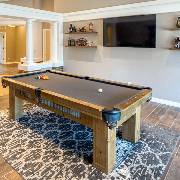 Basement game room with pool table and wall-mounted TV.