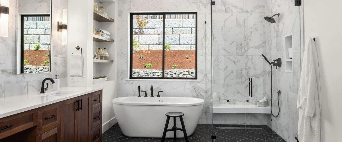 Spacious master bathroom with a large soaking tub, white marble walk-in shower, and dark wood double vanity with white countertops.