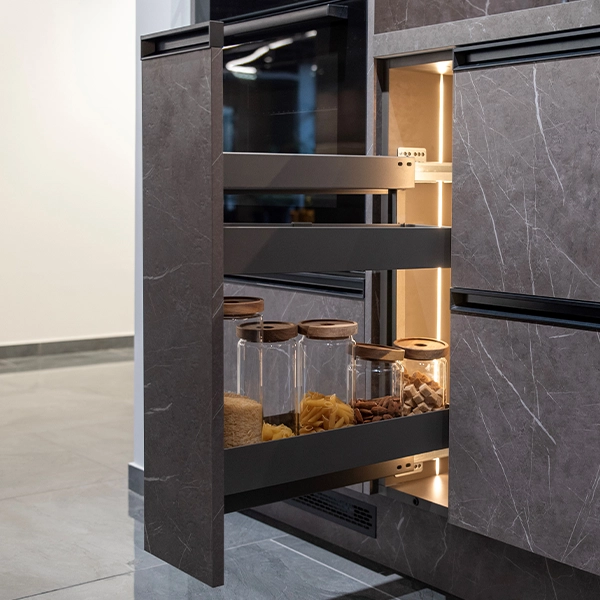Modern kitchen with pull-out pantry drawers and built-in lighting.